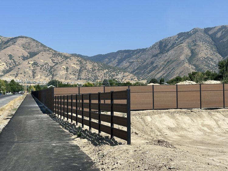 Integral composite fence with the Wasatch mountains behind it in Northern Utah
