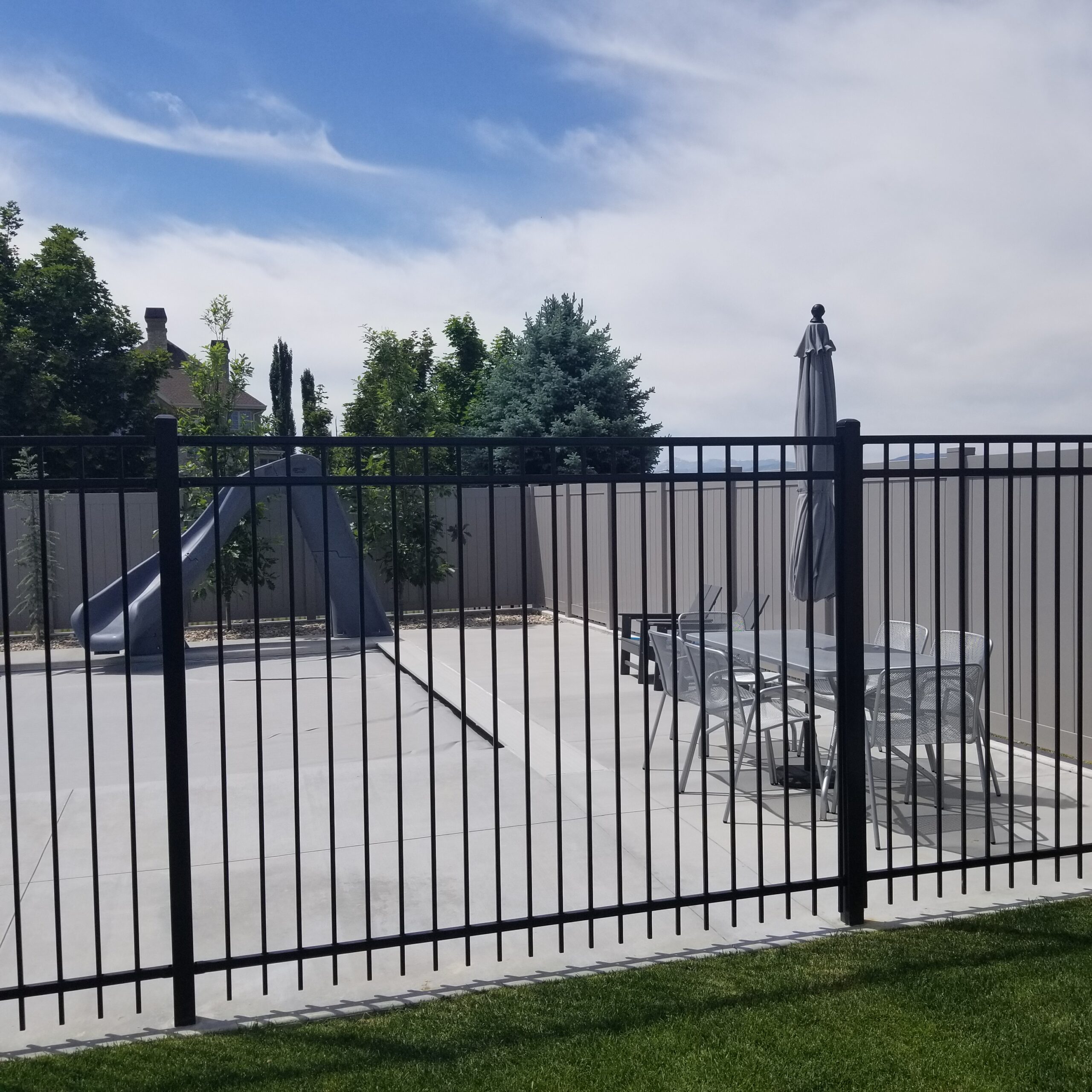 Black ornamental iron fence lining a residential Utah yard